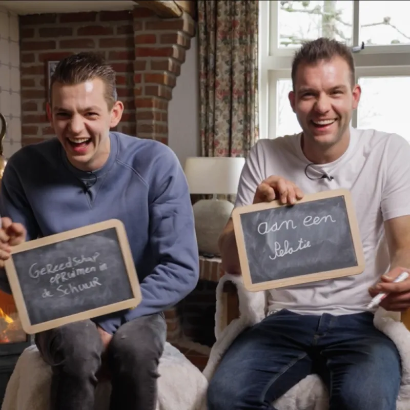 twee mannen met krijtbordjes in hun handen