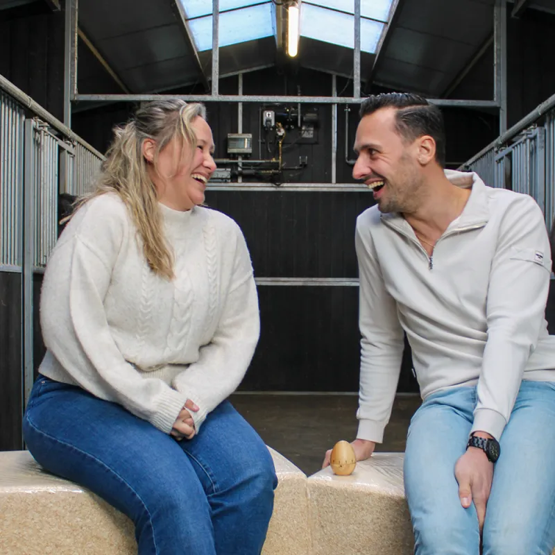 een vrouw en een man in een paardenstal