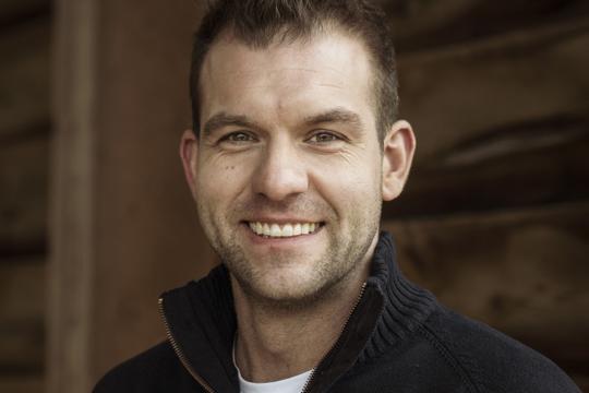 een man poseert in een stal