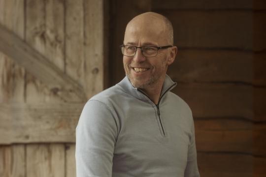 een man poseert in een stal