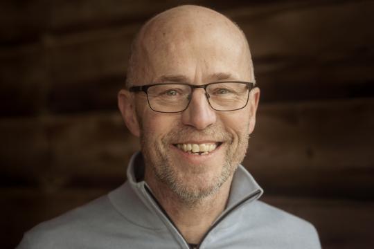 een man poseert in een stal