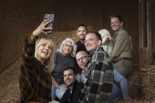 een vrouw maakt een selfie met een groep mensen