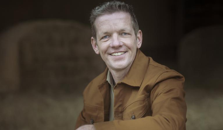 een man poseert in een stal