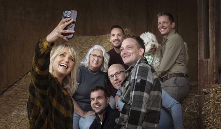 een vrouw maakt een selfie met een groep mensen