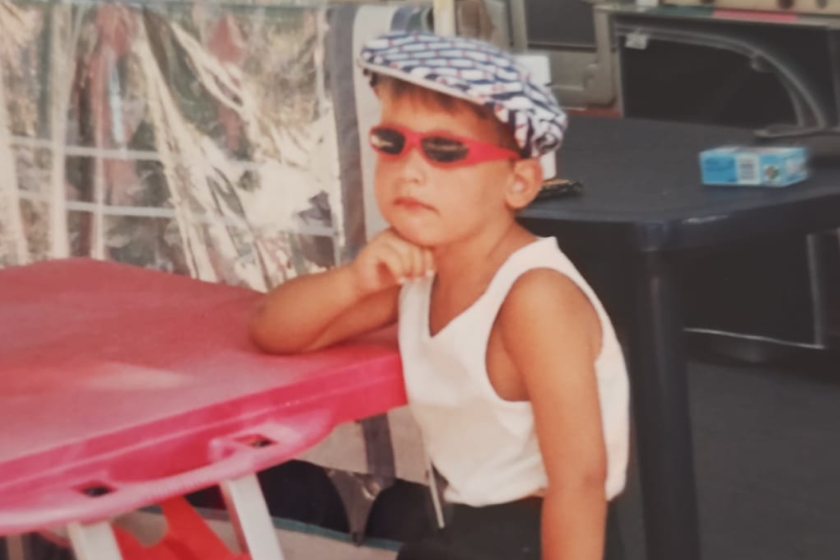 een jongetje met pet en zonnebril