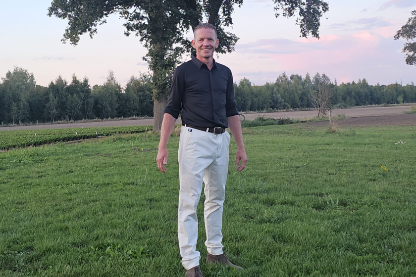 een man poseert in een grasveld