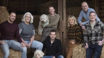 een groep mensen poseert in een stro-opslag
