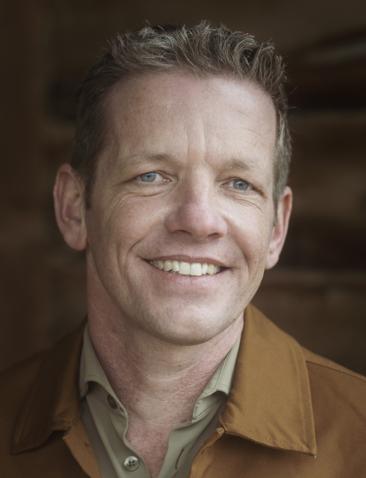 een man poseert in een stal