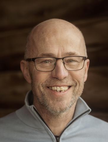 een man poseert in een stal