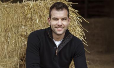 een man poseert in een stal