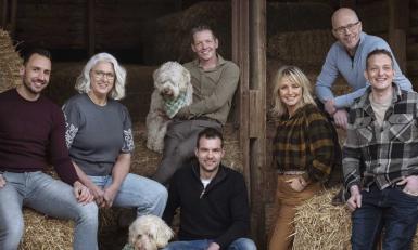 een groep mensen poseert in een stro-opslag