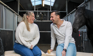 een vrouw en een man in een paardenstal